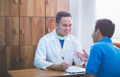 dental team talking with smiling patient