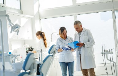 dental team talking with smiling patient